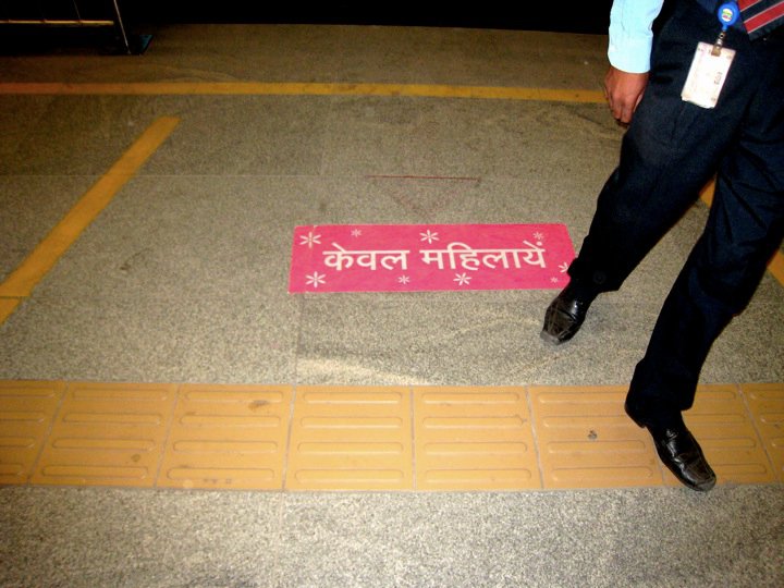 A sign reading "women only" in Hindi on the platform of the Delhi Metro.