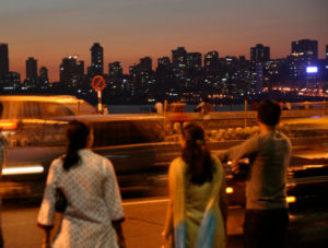 Pedestrians watch traffic in Mumbai