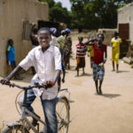 Boy on bicycle in Burkina Faso. Photo by Olivier Girard/CIFOR. Cropped.