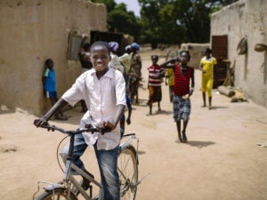 Boy on bicycle in Burkina Faso. Photo by Olivier Girard/CIFOR. Cropped.